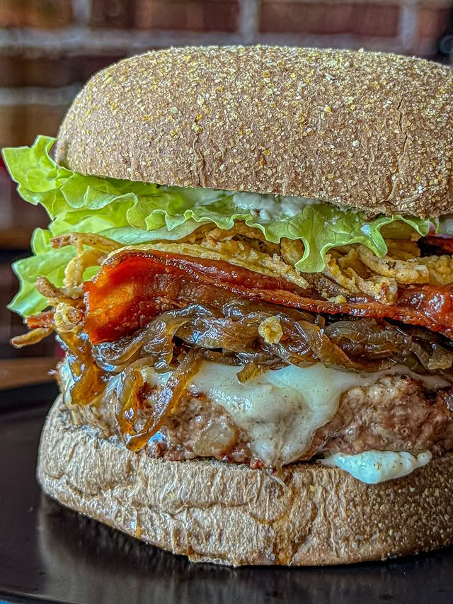 Hambúrguer alto com pão integral, alface, cebola e molho